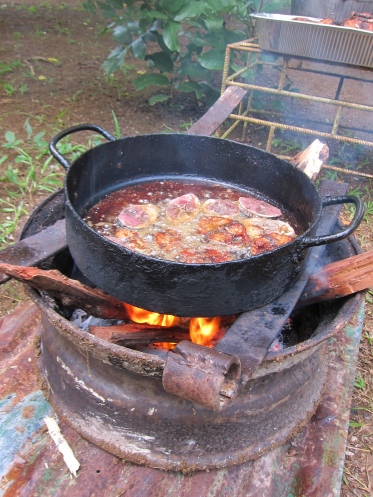 One of the many makeshift stoves with frying fish in it